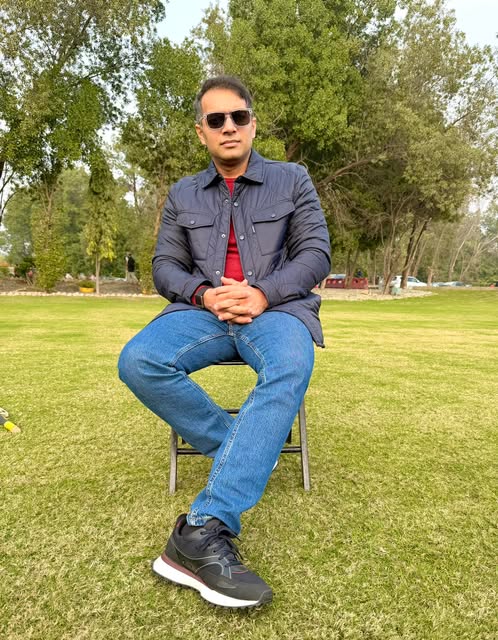 Syed Umair Hassan seated outdoors on a lawn